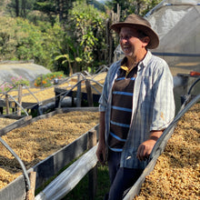 Load image into Gallery viewer, Carlos Arrieta shares a laugh with OCR Green Buyer Roland Glew amongst the raised drying beds at the ARBAR micromill