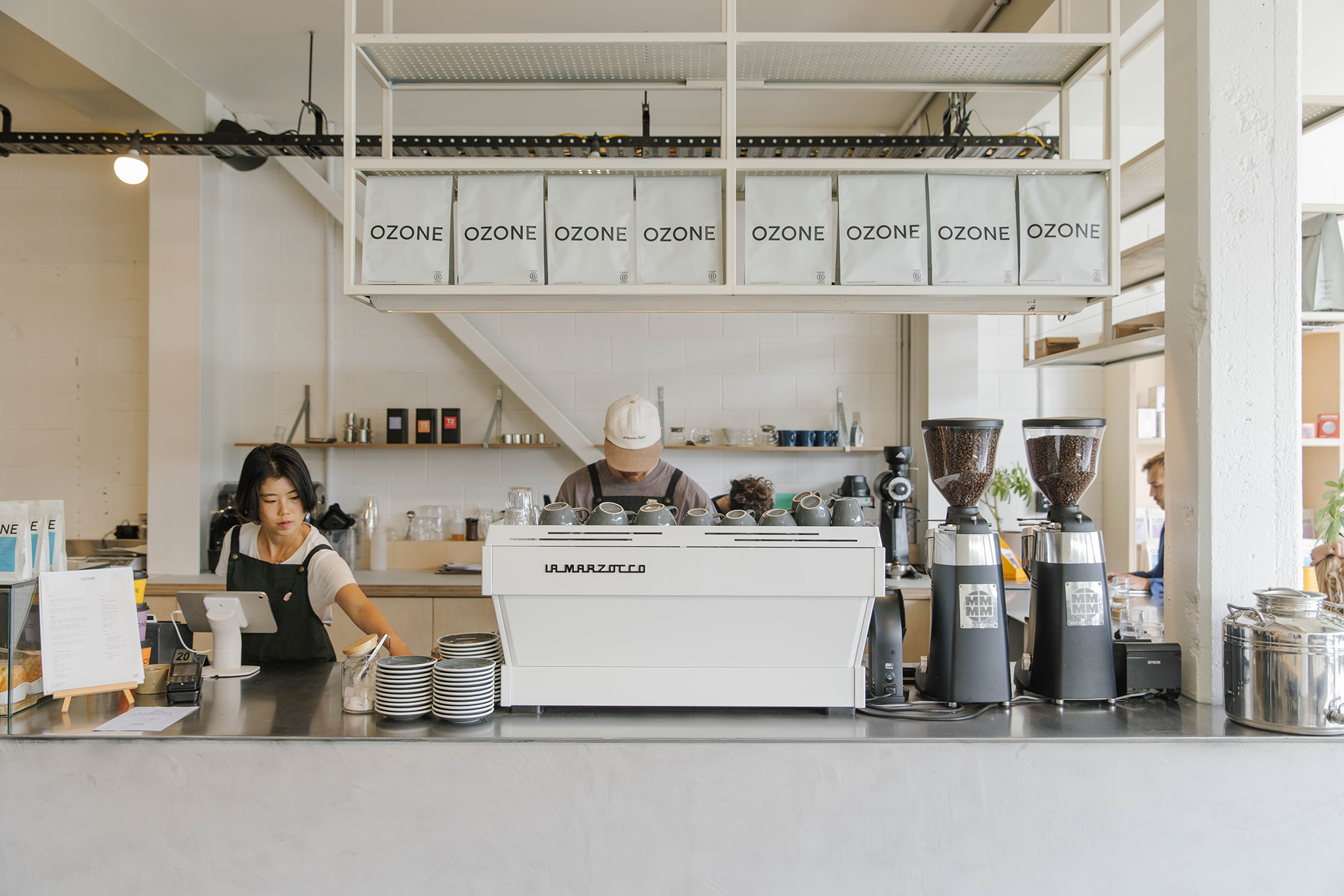 Ozone Coffee Christchurch - Coffee shop interior with staff behind the counter and 'Ozone' branding.