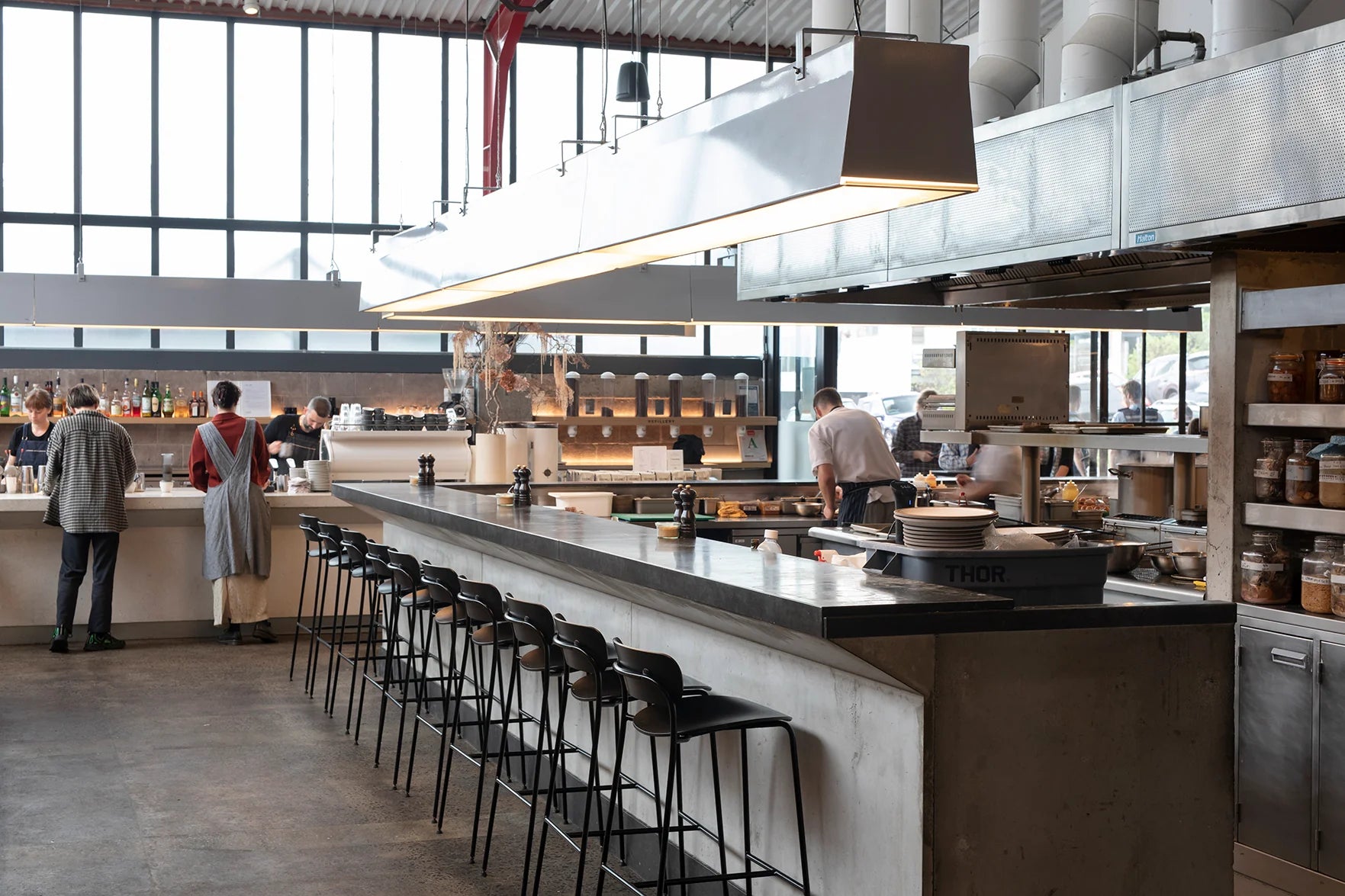Ozone Coffee Auckland - Modern kitchen with bar stools and people working